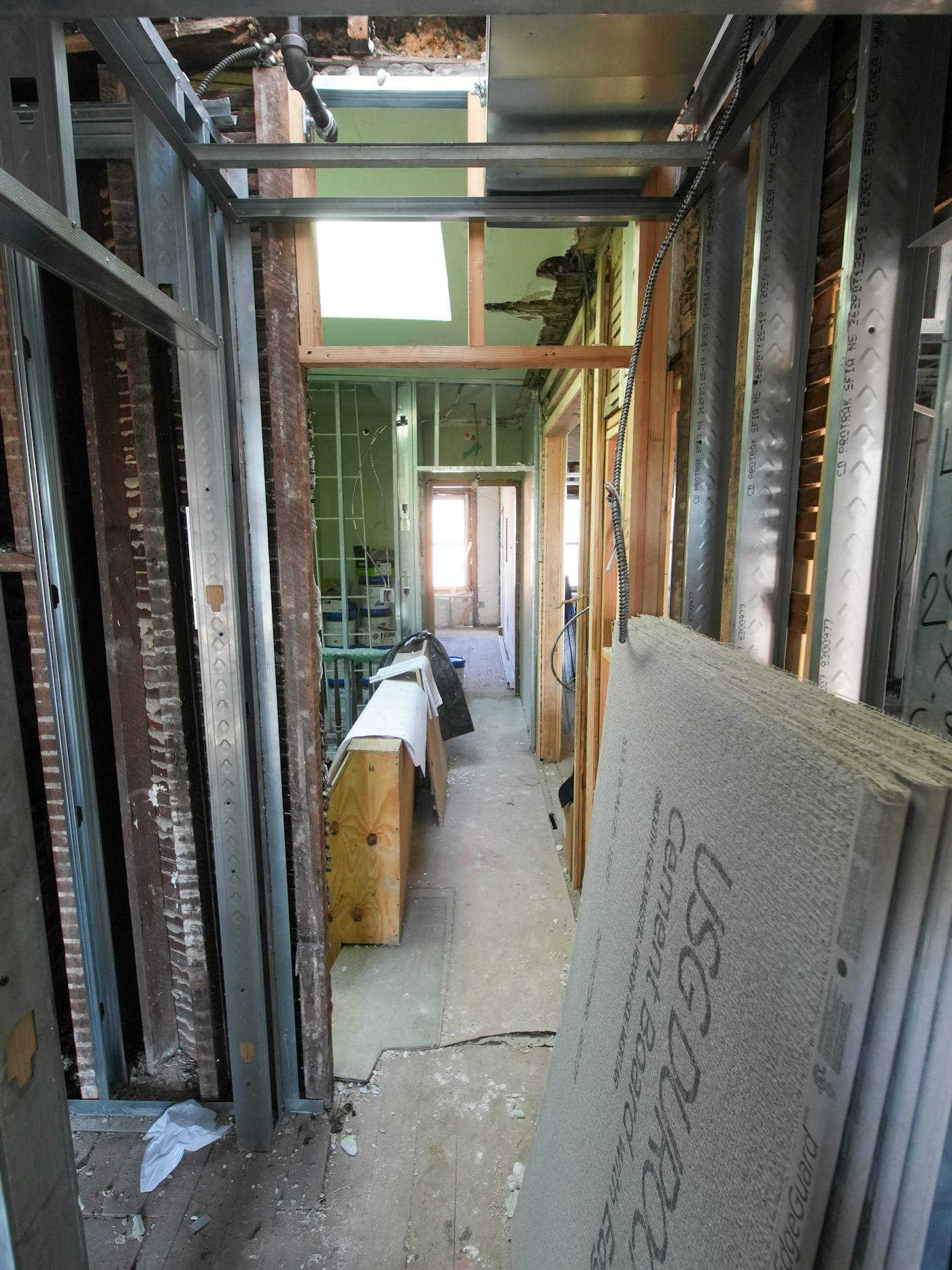 Renovation corridor with board materials staged for drywall finishing