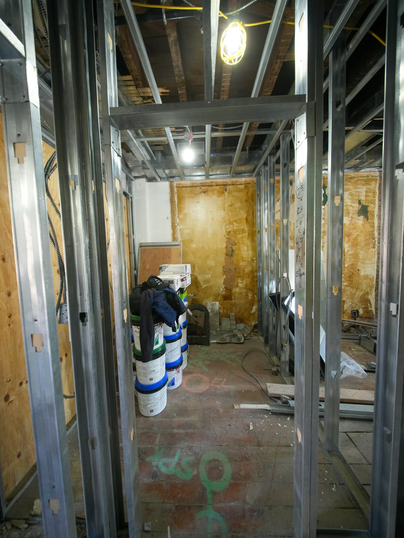 Metal stud framing and joint compound buckets during drywall finishing