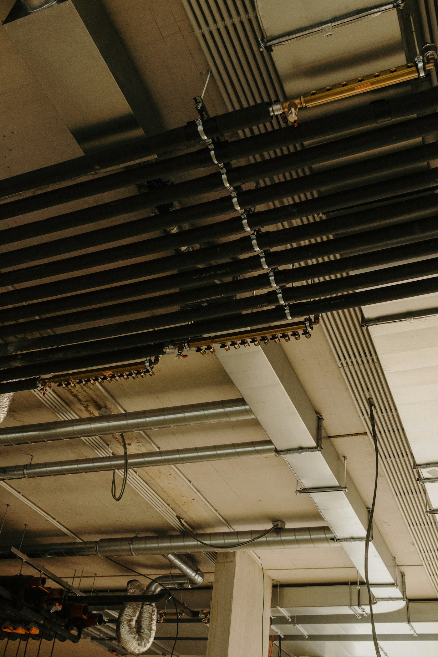 Exposed pipes and unfinished walls after water damage drywall removal